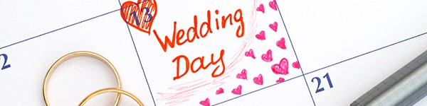 Reminder Wedding day in calendar with pen and two wedding rings.