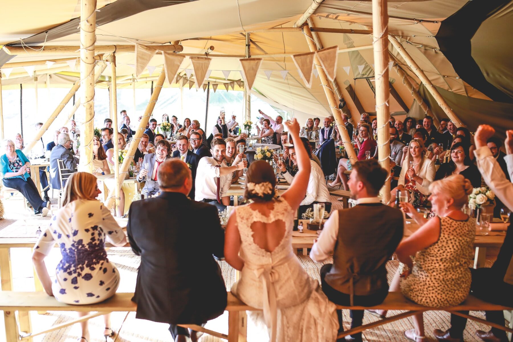Happily married couple with guest watching cheering to a gorgeous evening wedding breakfastt